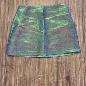 Light Before Dark holographic mini skirt in pink and green iridescent fabric.